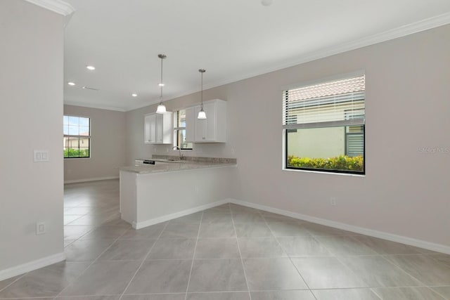 kitchen with ornamental molding, a sink, white cabinetry, light tile patterned floors, and baseboards