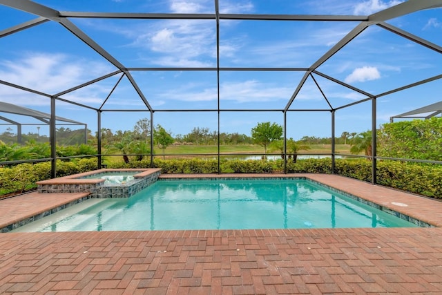 view of pool featuring glass enclosure, a pool with connected hot tub, a patio, and a water view