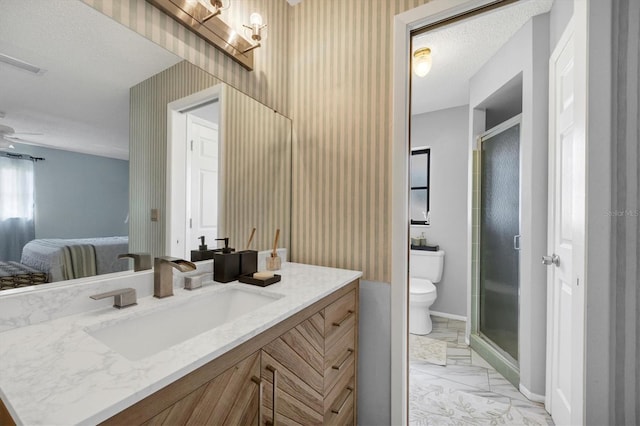 bathroom featuring vanity, toilet, ceiling fan, and a shower with shower door