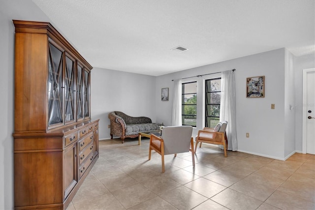 living area featuring light tile patterned floors and a textured ceiling