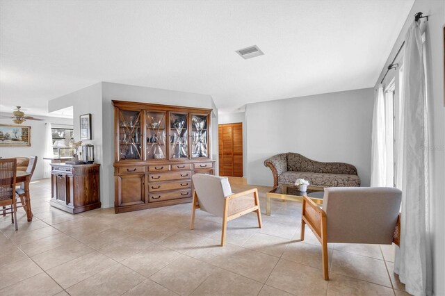 sitting room with ceiling fan and light tile patterned flooring