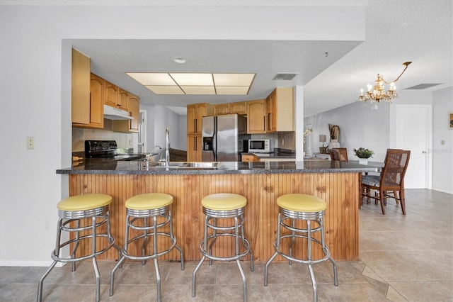 kitchen with kitchen peninsula, stainless steel fridge with ice dispenser, black stove, and an inviting chandelier