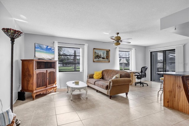 tiled living room featuring ceiling fan and a textured ceiling