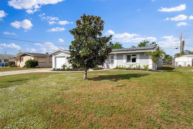 ranch-style home featuring solar panels, a garage, and a front lawn