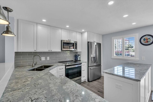 kitchen featuring white cabinets, stainless steel appliances, light stone countertops, and sink