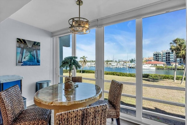 sunroom featuring a water view