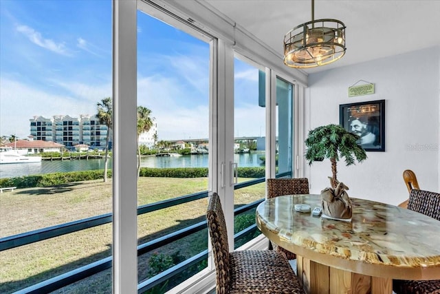 sunroom featuring a water view