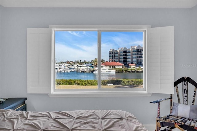 bedroom with a water view and multiple windows