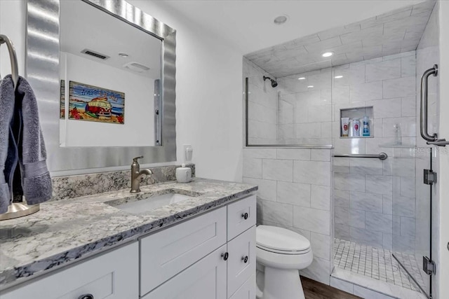 bathroom featuring hardwood / wood-style floors, vanity, toilet, and walk in shower