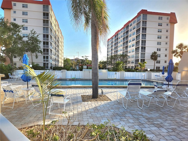 community pool with fence and a patio area