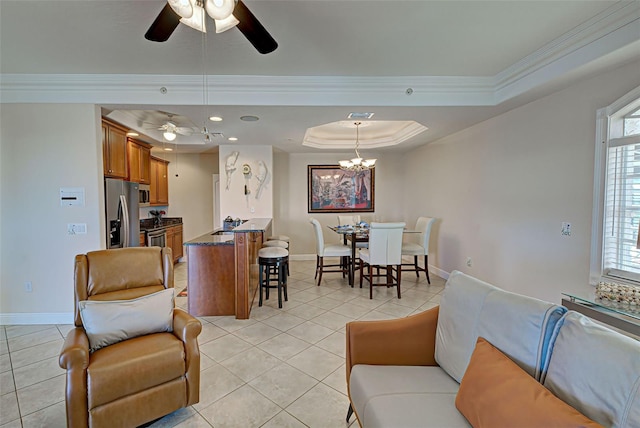 living room with plenty of natural light, ornamental molding, and a tray ceiling