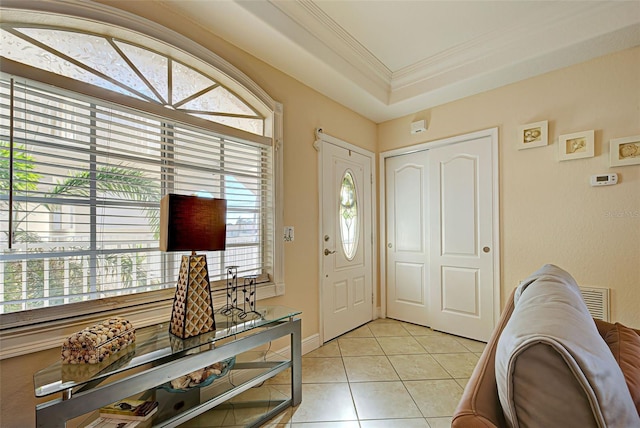 foyer with crown molding, light tile patterned floors, and a healthy amount of sunlight