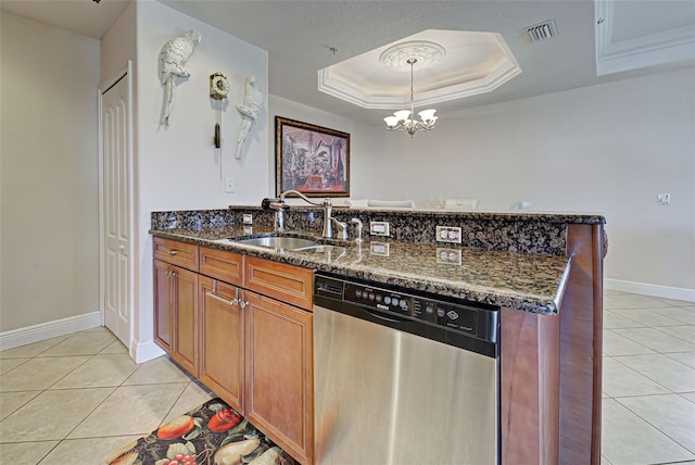 kitchen with dishwasher, a raised ceiling, sink, dark stone countertops, and decorative light fixtures