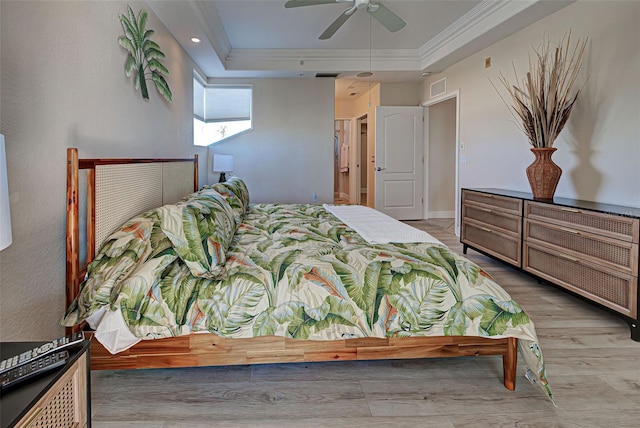 bedroom featuring a raised ceiling, ceiling fan, crown molding, and light wood-type flooring