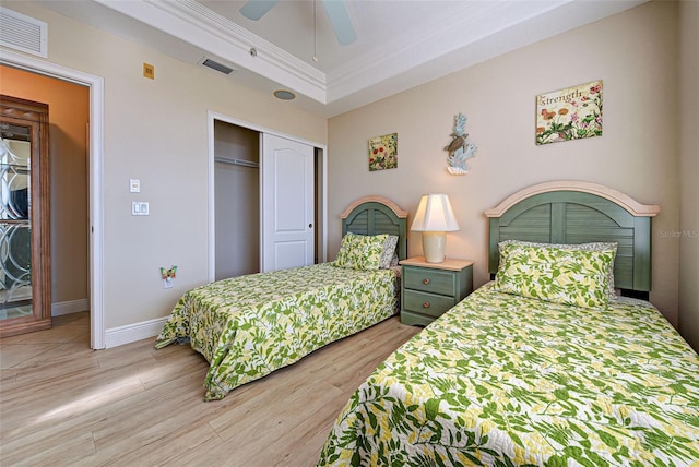 bedroom with ceiling fan, a closet, ornamental molding, and light hardwood / wood-style flooring