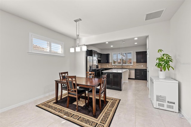 dining area featuring light tile patterned floors and sink