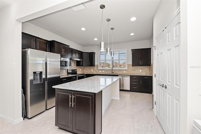 kitchen with a center island, pendant lighting, decorative backsplash, dark brown cabinets, and appliances with stainless steel finishes