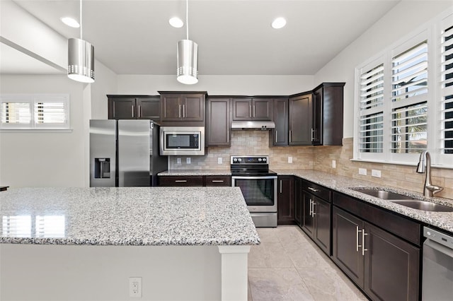 kitchen featuring decorative light fixtures, a healthy amount of sunlight, sink, and appliances with stainless steel finishes