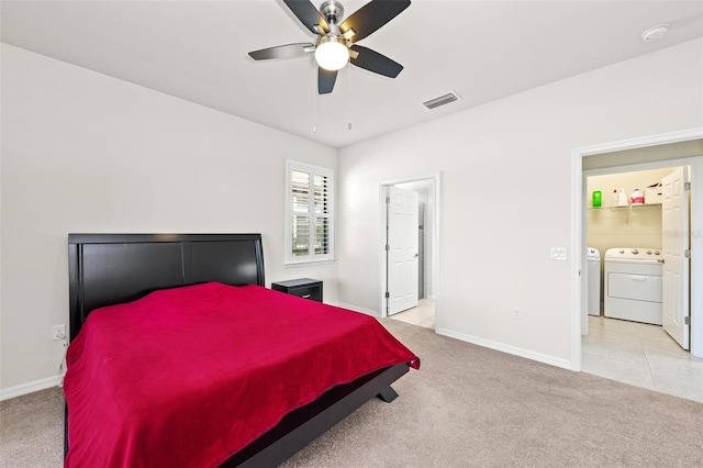 carpeted bedroom with ceiling fan, independent washer and dryer, and ensuite bath