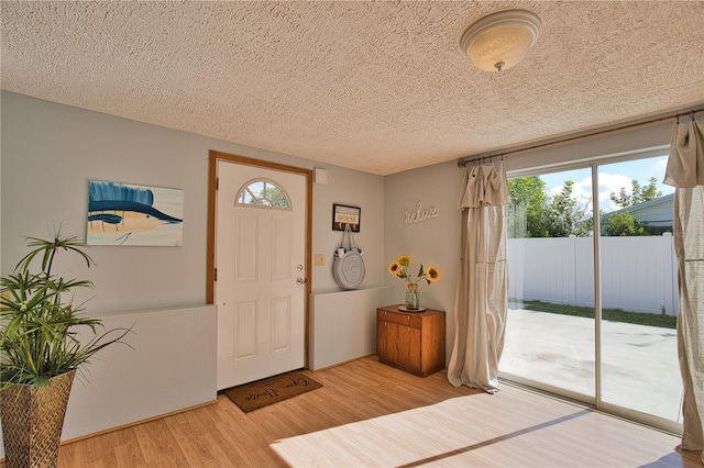 foyer with a textured ceiling and light hardwood / wood-style flooring