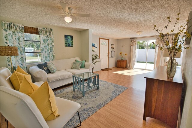 living room with ceiling fan, hardwood / wood-style floors, and a textured ceiling