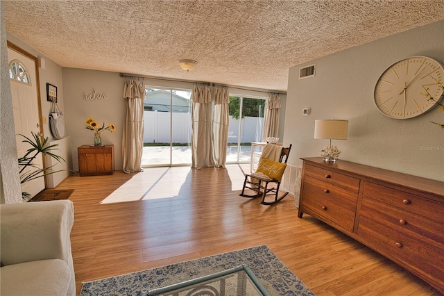 sitting room with a textured ceiling and light hardwood / wood-style flooring