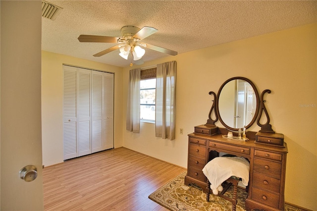 interior space with ceiling fan, a textured ceiling, and light wood-type flooring