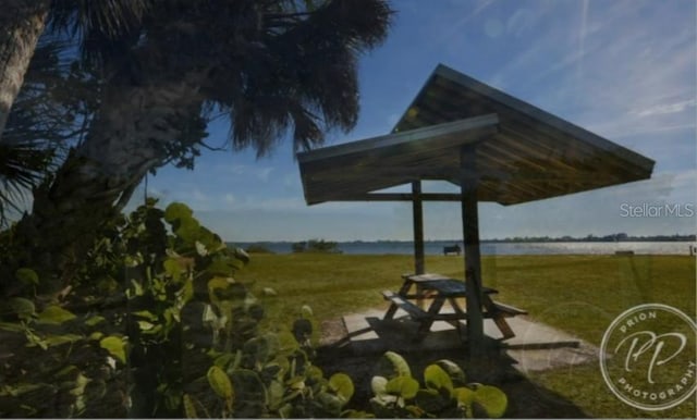 view of home's community featuring a water view and a lawn