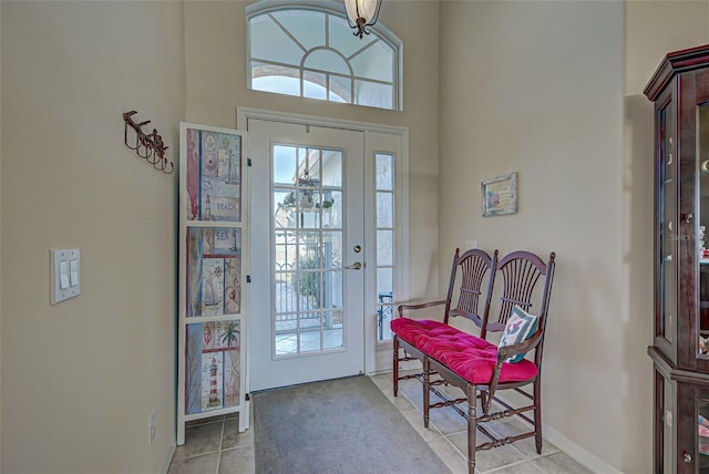 entryway with a high ceiling and light tile patterned floors