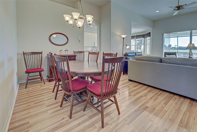 dining room with light hardwood / wood-style floors and ceiling fan with notable chandelier