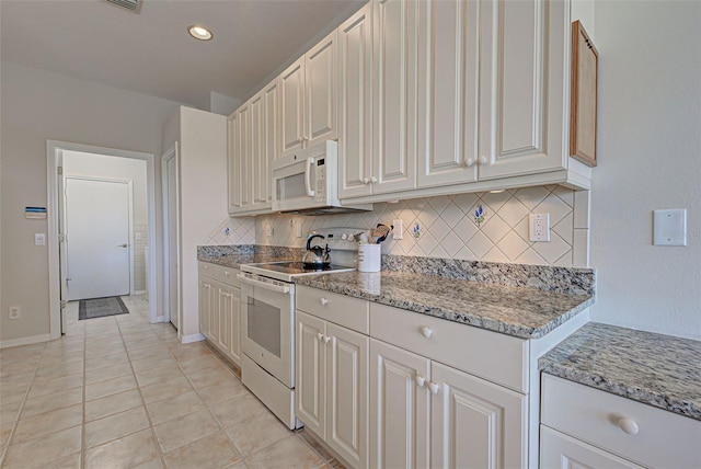 kitchen featuring light stone countertops, white appliances, white cabinets, tasteful backsplash, and light tile patterned floors