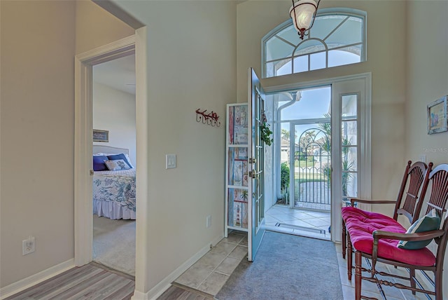 carpeted foyer entrance with a high ceiling