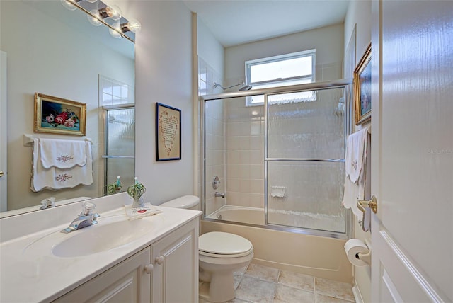 full bathroom with tile patterned flooring, toilet, vanity, and combined bath / shower with glass door