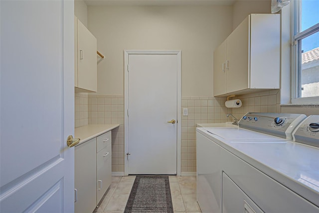 clothes washing area featuring washer and dryer, cabinets, light tile patterned floors, and sink