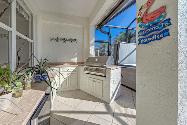 view of patio featuring grilling area, glass enclosure, and exterior kitchen