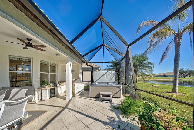 sunroom / solarium featuring ceiling fan and a water view