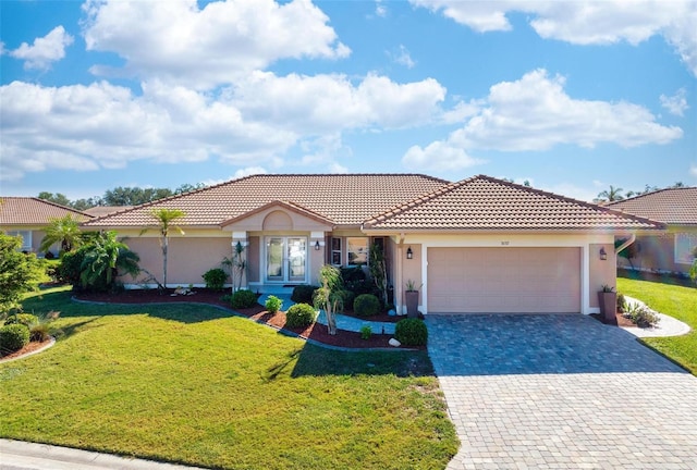 mediterranean / spanish-style house with a garage and a front lawn