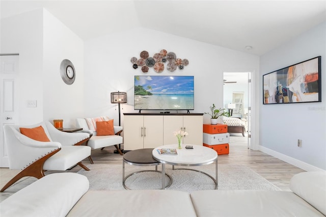 living room with light hardwood / wood-style floors, vaulted ceiling, and ceiling fan