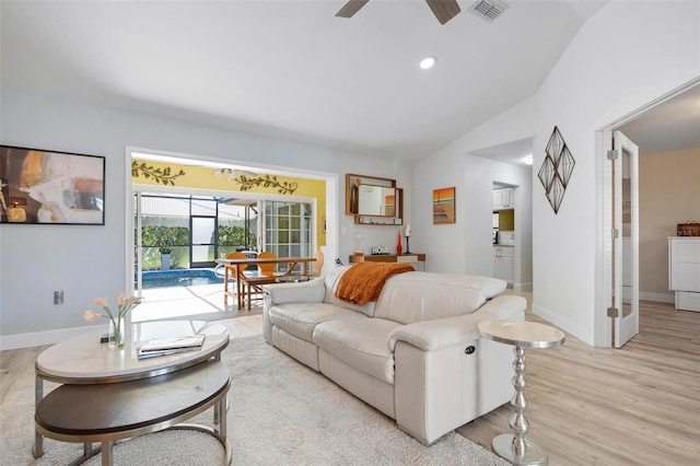 living room featuring ceiling fan, light hardwood / wood-style floors, and vaulted ceiling