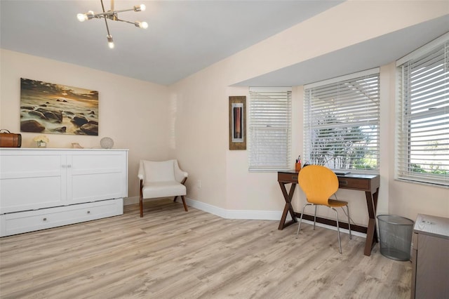 living area with light hardwood / wood-style floors and an inviting chandelier