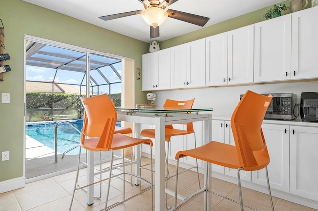 interior space with light tile patterned floors and ceiling fan