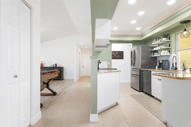 kitchen featuring stainless steel dishwasher, sink, light tile patterned floors, white cabinets, and lofted ceiling