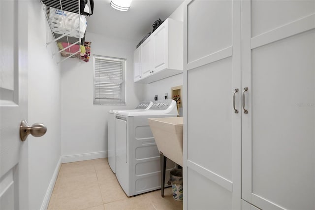 laundry room featuring cabinets, light tile patterned flooring, and washer and dryer