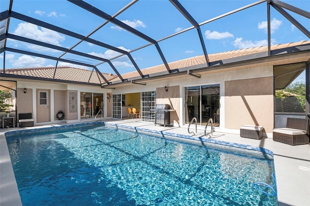 view of swimming pool with glass enclosure, a patio, and grilling area