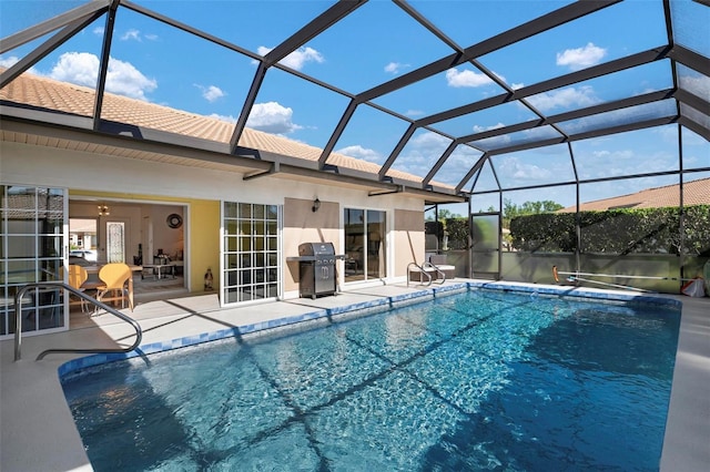 view of swimming pool featuring glass enclosure, area for grilling, and a patio