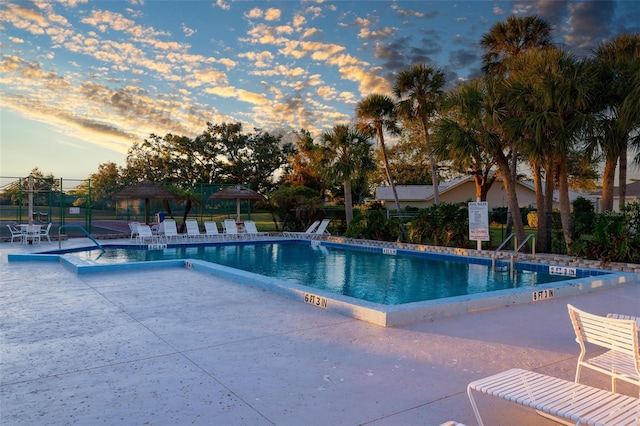 pool at dusk with a patio