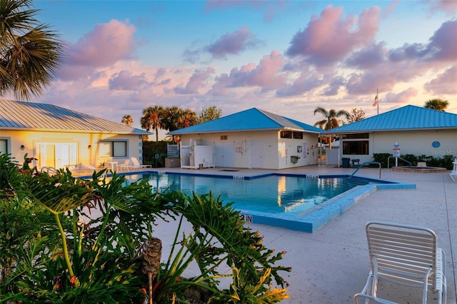 pool at dusk featuring a patio area