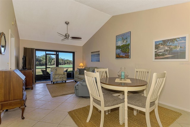 dining room featuring ceiling fan, light tile patterned flooring, and vaulted ceiling