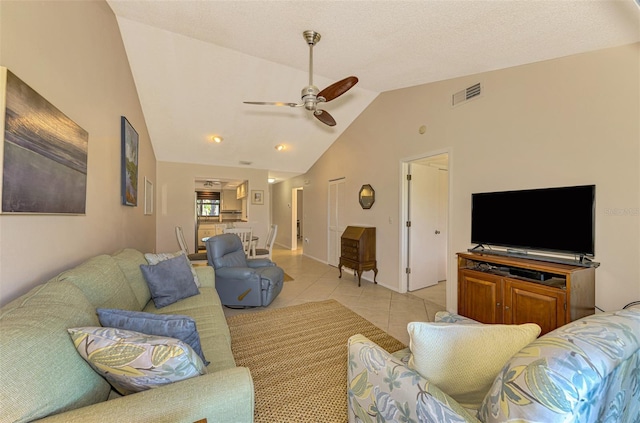 living room with ceiling fan, light tile patterned flooring, and lofted ceiling