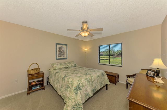 carpeted bedroom featuring ceiling fan and a textured ceiling